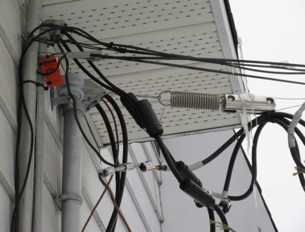 Entrée électrique aérienne résidentielle montrant des câbles et raccordements extérieurs nécessitant une mise à niveau conforme au Code électrique du Québec.