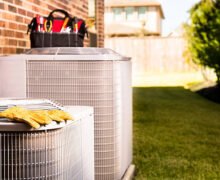 Thermopompe résidentielle extérieure avec outils de technicien, utilisée pour le chauffage et la climatisation d’une maison au Québec.
