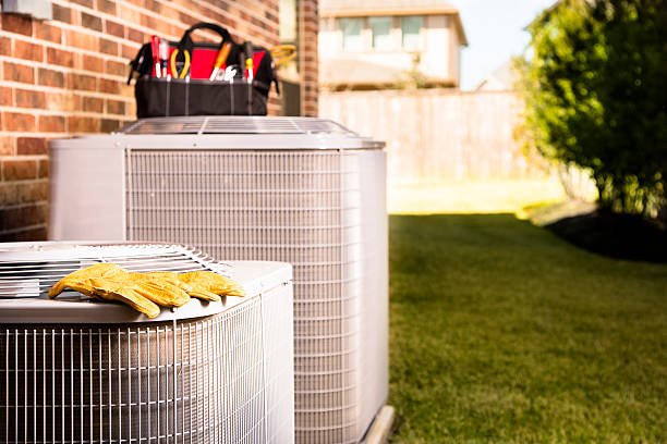 Thermopompe résidentielle extérieure avec outils de technicien, utilisée pour le chauffage et la climatisation d’une maison au Québec.