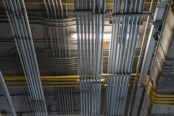 Installation de conduits électriques commerciaux au plafond, incluant conduits EMT et câbles supportés selon les normes du Code électrique du Québec.