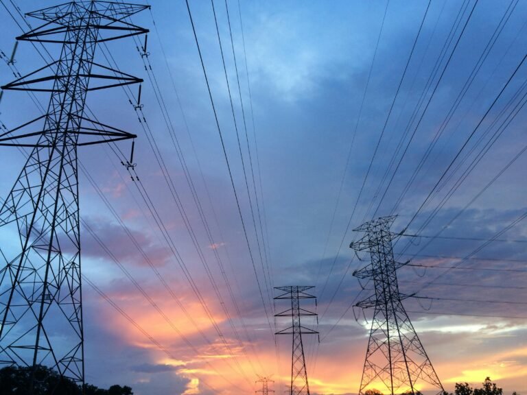 Lignes électriques haute tension au coucher du soleil illustrant la distribution d’énergie au Québec.